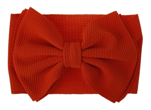 Close-up of burnt orange bullet fabric texture on large baby bow headband