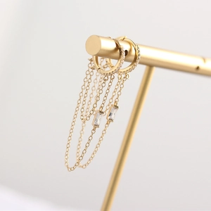 Macro detail of gold S925 silver hoop earrings with chain tassels and crystal charms