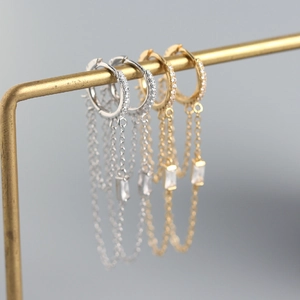 Macro shot of S925 sterling silver chain tassel earrings with crystals in gold and silver