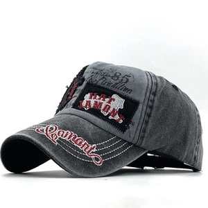 Close-up of vintage washed grey cotton baseball cap featuring embroidered letters and patch