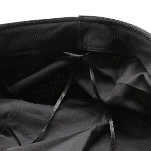 Macro shot of black houndstooth newsboy hat interior with sweatband and adjustable drawstring