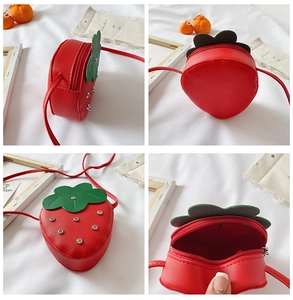 Detail view of red strawberry crossbody bag for kids with studs and zip closure