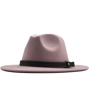 Detail of pink fedora hat featuring a brown textured band and metallic buckle
