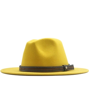 Vibrant yellow felt fedora hat with brown leather band and metal buckle on white background