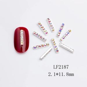 Macro detail of long silver metal nail charms with AB rhinestones for 3D manicures