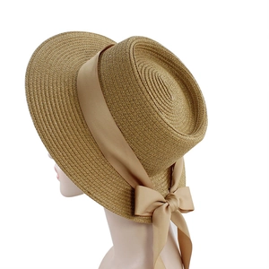 Flat top straw hat with a light brown ribbon bow for sun protection and beach style