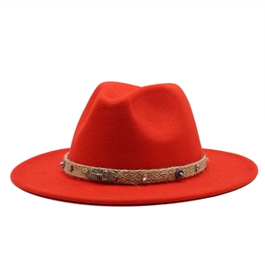 Detail of red wool felt fedora featuring a scorpion metal buckle and braided rope band