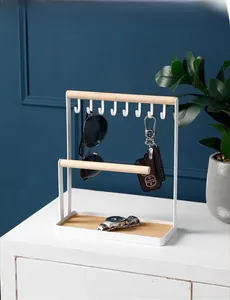 Detail of white metal jewelry stand with 8 hooks and wooden tray for key storage