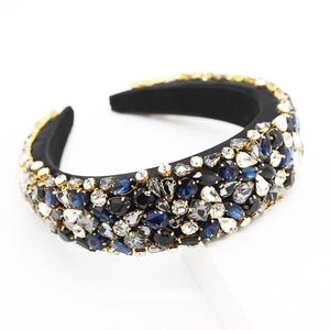 Gros plan d'un serre-tête baroque avec strass bleus et noirs et griffes dorées