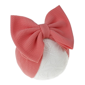 Macro detail of coral pink waffle knit fabric on oversized baby bow headband