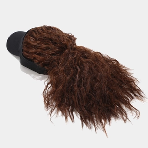 Vue détaillée de la perruque brune bouclée fixée à une casquette de baseball noire