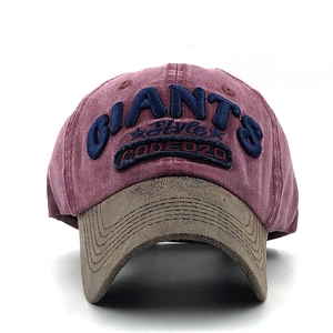 Close-up of vintage washed red baseball cap with detailed 3D embroidery and contrast brim