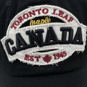 Detailed macro view of Canada maple leaf embroidery on black cotton baseball cap