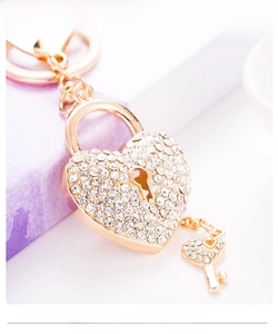 Macro shot of gold heart-shaped lock keychain with sparkling crystal rhinestones and tiny key
