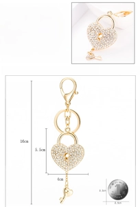 Detail view of heart-shaped gold keychain with sparkling rhinestones and small key charm