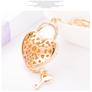 Close-up of golden hollowed heart-shaped lock keychain with intricate filigree details