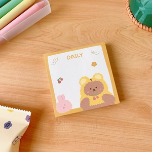 Close-up of a cute cartoon bear sticky note pad with daily schedule design on wood background