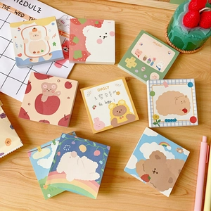 Variety of cute cartoon bear sticky notes and memo pads on a wooden desk setup