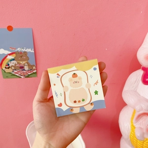 Detailed view of a cute cartoon bear sticky notepad with colorful orange bear cover art