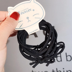 Vista dettagliata di elastici neri per capelli su supporto a forma di gatto