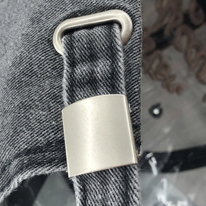 Detailed macro of the matte silver metal buckle and grey cotton twill on a baseball cap