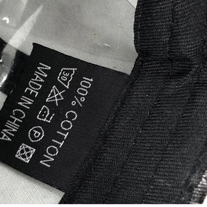 Detail shot of the 100% cotton material tag and care instructions for the baseball cap