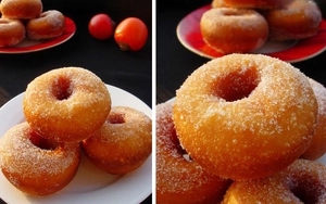 Close-up of golden fried donuts with granulated sugar coating on a red plate