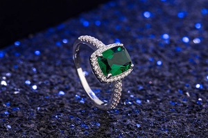 Macro detail of silver ring with square emerald cut green gemstone and small diamonds