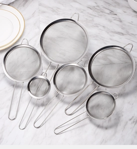 Ensemble de six passoires en acier inoxydable de tailles variées sur table en marbre