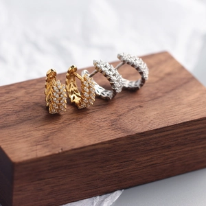 Macro detail of gold and silver wheat ear hoop earrings with sparkling cubic zirconia pavé