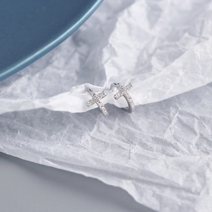 Macro shot of silver S925 sterling silver cross earrings with sparkling zircon stones