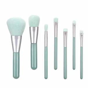 Detailed flat lay of 7-piece mint green makeup brush set with silver metal ferrules