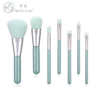 Detailed flat lay of 7-piece mint green makeup brush set with silver metal ferrules
