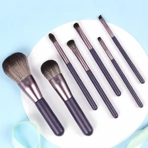 Detailed view of a 7-piece purple professional makeup brush set arranged on a white platform