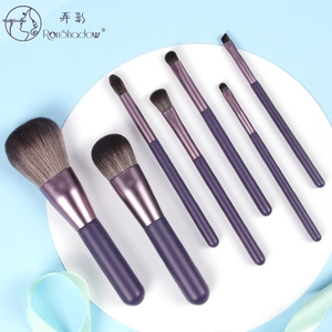 Detailed view of a 7-piece purple professional makeup brush set arranged on a white platform