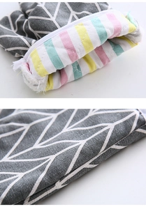 Close-up of thick heat-resistant oven mitt showing stripe lining and geometric cotton fabric