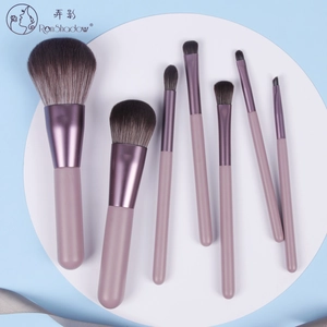 Detail view of 7-piece makeup brush set with smoky pink handles and purple metal tubes