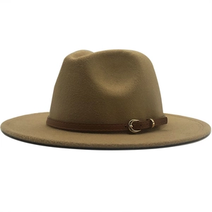 Detail of camel fedora hat featuring a brown leather band and gold horseshoe buckle