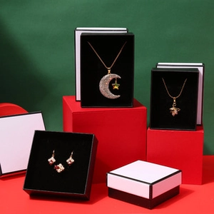 Classic black and white jewelry gift boxes for necklaces and earrings displayed on a platform