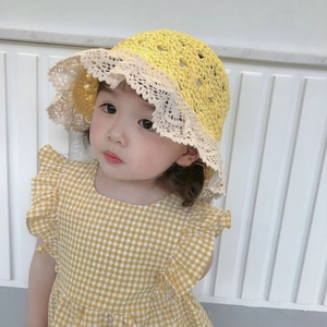 Close-up of yellow crochet sun hat with delicate beige lace trim for toddlers