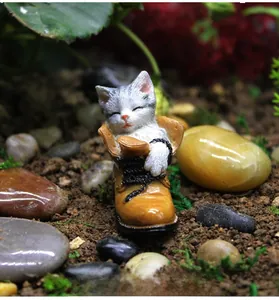 Macro detail of a resin miniature kitten figurine sleeping inside an orange shoe for gardens