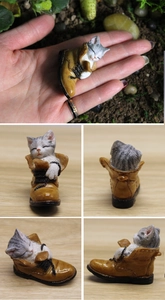 Macro detail of miniature cat sleeping in a boot resin figurine for micro landscapes