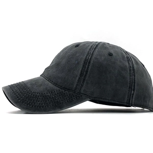 Macro detail of dark grey washed cotton baseball cap showing vintage distressed texture