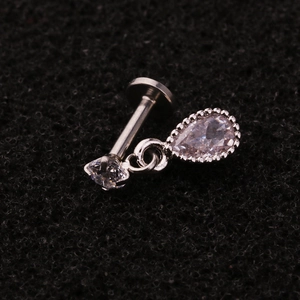 Close-up of silver steel cartilage stud with round and teardrop zircon pendants