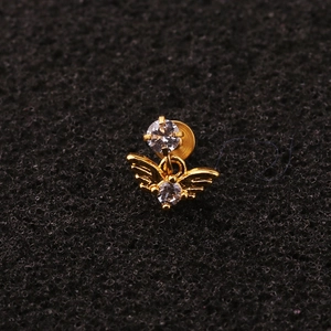 Close-up of golden angel stud earring with zircon stones on black background