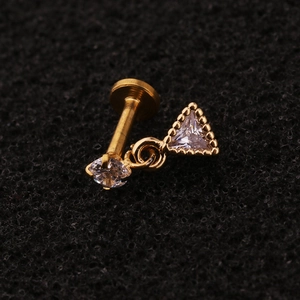 Gold stainless steel zircon labret with hanging triangle pendant on black surface