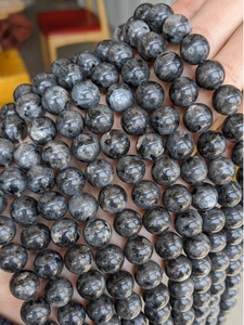 Close-up of natural dark grey Larvikite round beads showing unique optical luster