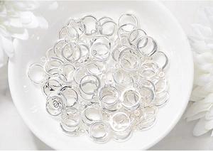 Close-up of silver metal hoop earring findings for DIY jewelry making in a ceramic bowl