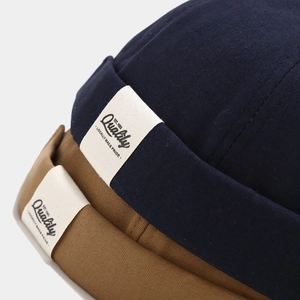 Detailed close-up of high-density cotton fabric and side label on minimalist docker hats