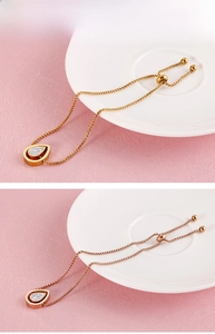 Detail of adjustable stainless steel teardrop pendant bracelets with pavé rhinestones